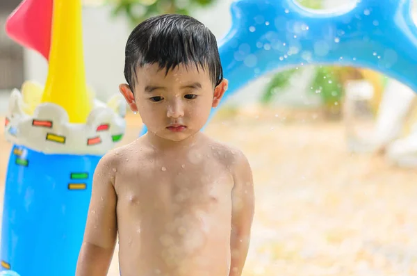 Niño asiático jugando en la piscina inflable del bebé en verano caliente — Foto de Stock