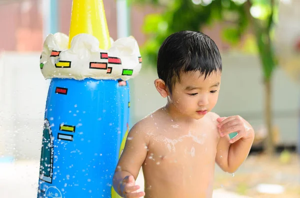 Niño asiático jugando en la piscina inflable del bebé en verano caliente — Foto de Stock