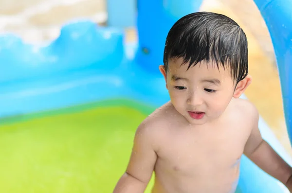 Asian kid playing in inflatable baby swimming pool on hot summer — Stock Photo, Image