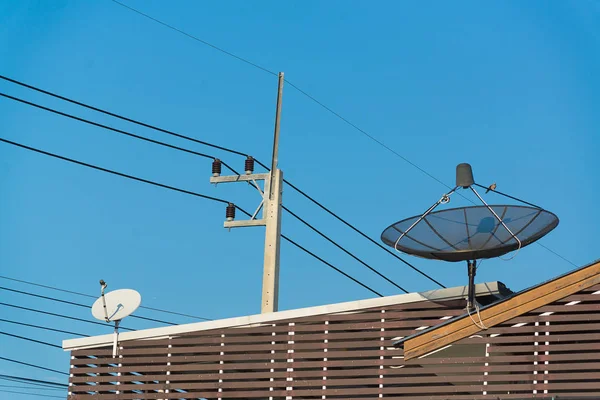 Prato de satélite preto grande no telhado com céu azul . — Fotografia de Stock
