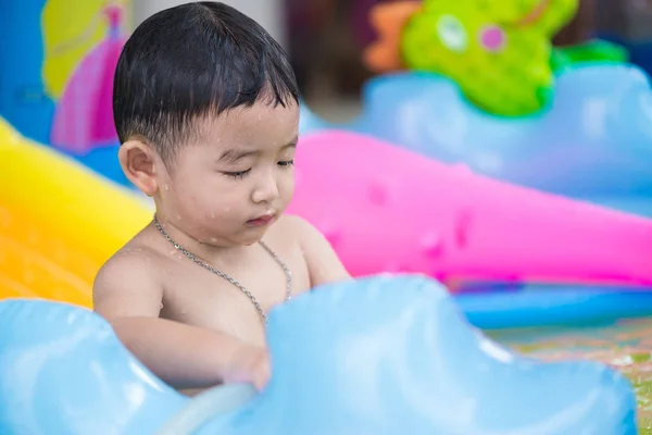 Asian kid playing in inflatable baby swimming pool on hot summer — Stock Photo, Image