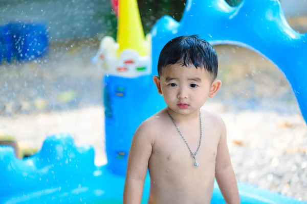 Niño asiático jugando en la piscina inflable del bebé en verano caliente — Foto de Stock