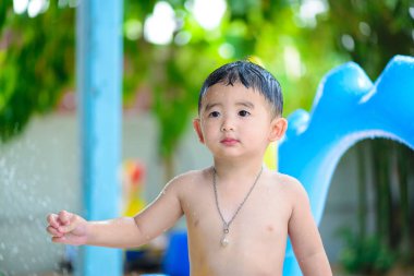Asyalı çocuk şişme bebek yüzme havuzunda sıcak yaz oynarken