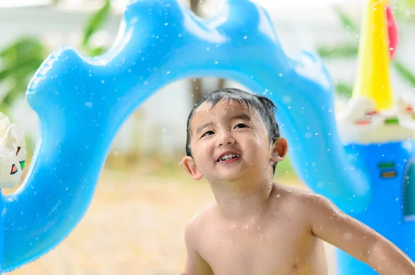 Asian kid playing in inflatable baby swimming pool on hot summer — Stock Photo, Image