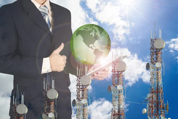 Double exposure of businessman using tablet with green earth pla