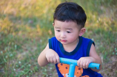Üzgün Asyalı Çocuk Bahçesi sunlig altında tahterevalli tahtaya sürme