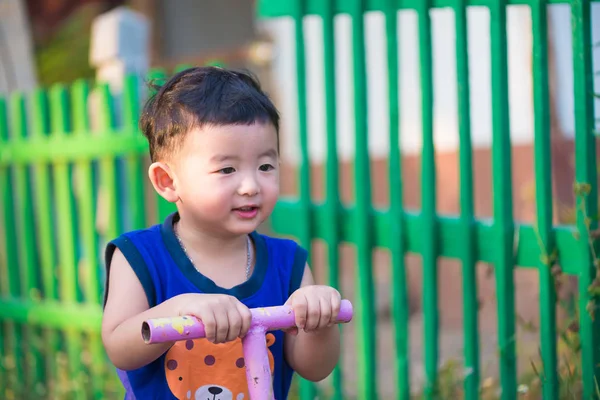 Asiático niño a caballo balancín en el patio de recreo . — Foto de Stock