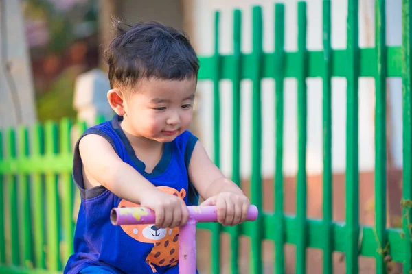 Asian kid riding seesaw board at the playground. — Stock Photo, Image