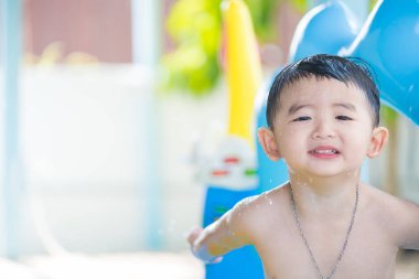 Şişme bebek havuzda tek başına oynarken üzgün Asyalı çocuk.
