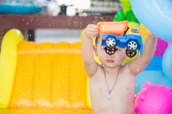 Asiatisches Kind spielt an heißen Sommertagen im aufblasbaren Babypool — Stockfoto
