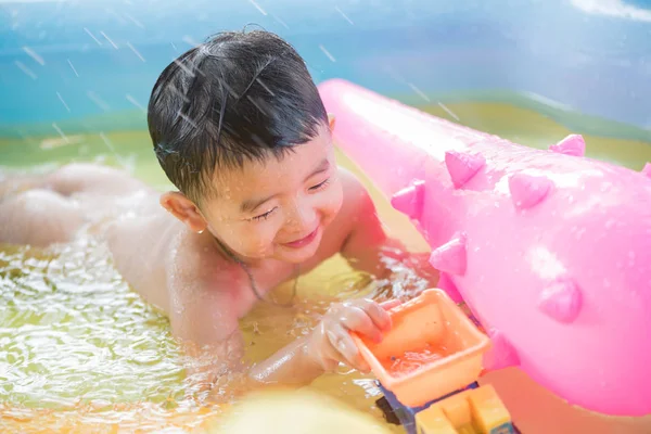 Asiatiska kid spelar i uppblåsbara babypool på het sommar — Stockfoto