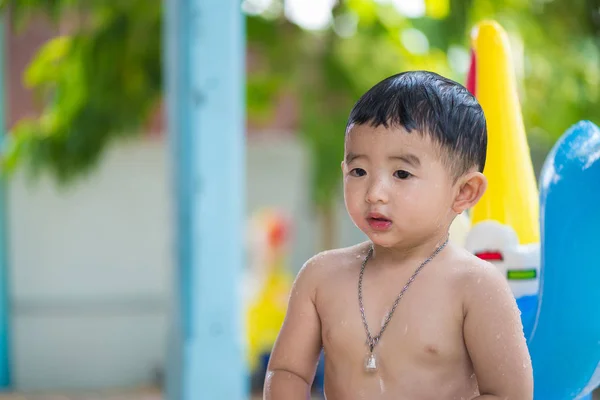 Niño asiático jugando en la piscina inflable del bebé en verano caliente — Foto de Stock