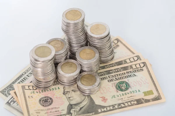 Кучи монет и долларовая валюта на белом фоне — стоковое фото