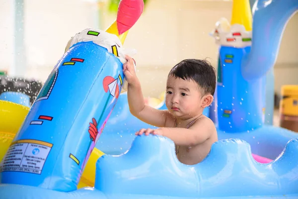 Triste asiático niño jugando solo en inflable bebé piscina — Foto de Stock