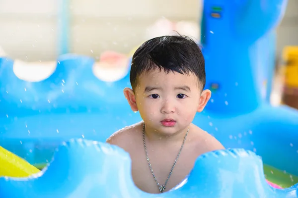 Asian kid playing in inflatable baby swimming pool on hot summer — Stock Photo, Image