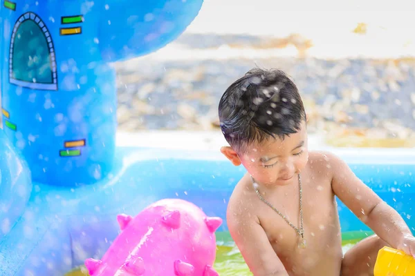 Menina asiática jogando na piscina inflável do bebê no verão quente — Fotografia de Stock