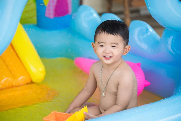 Asiatiska kid spelar i uppblåsbara babypool på het sommar — Stockfoto