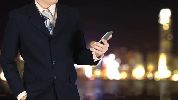 Doble exposición del hombre de negocios sosteniendo el teléfono inteligente en ci borrosa — Foto de Stock