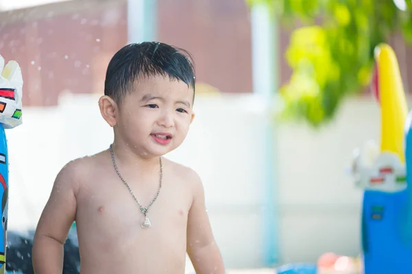 Niño asiático jugando en la piscina inflable del bebé en verano caliente — Foto de Stock