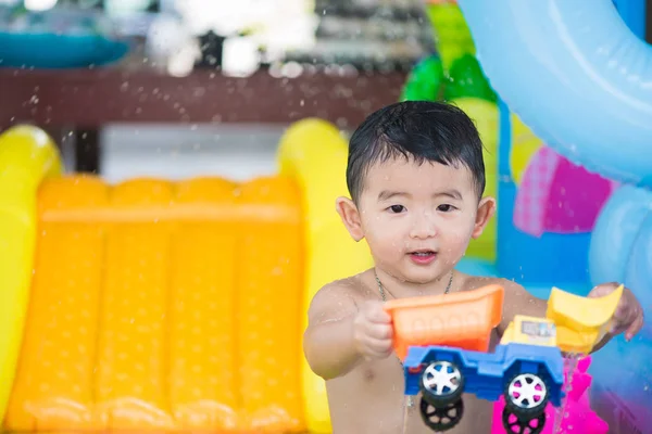 Niño asiático jugando en la piscina inflable del bebé en verano caliente — Foto de Stock