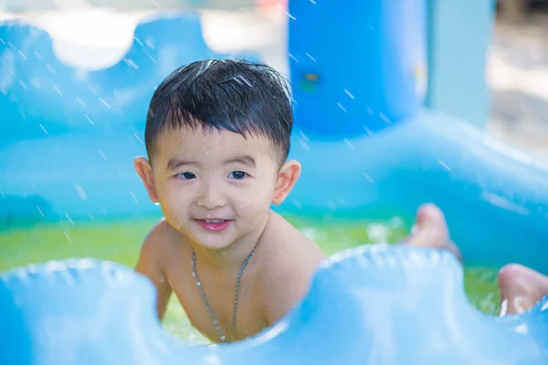 Niño asiático jugando en la piscina inflable del bebé en verano caliente — Foto de Stock