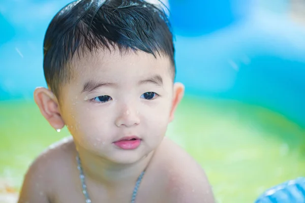 Niño asiático jugando en la piscina inflable del bebé en verano caliente — Foto de Stock