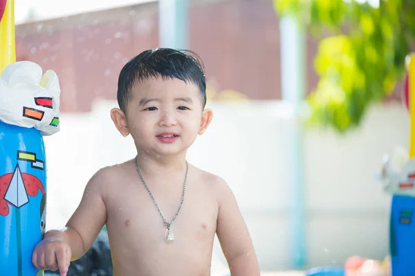 Niño asiático jugando en la piscina inflable del bebé en verano caliente — Foto de Stock