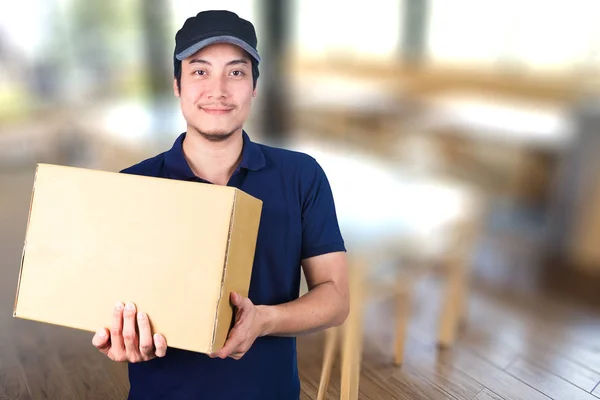 Asiático sorriso Entrega homem com caixa de papelão na mão pé res — Fotografia de Stock