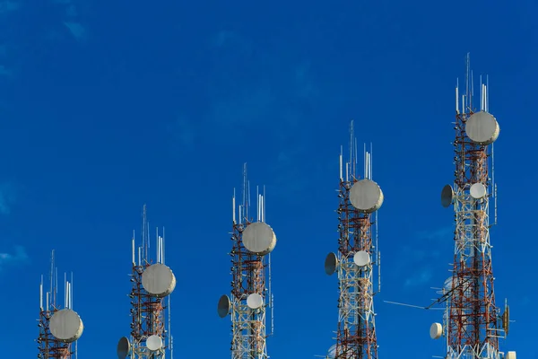 Torres de telecomunicaciones dispuestas como un gráfico de barras. sobre azul claro — Foto de Stock
