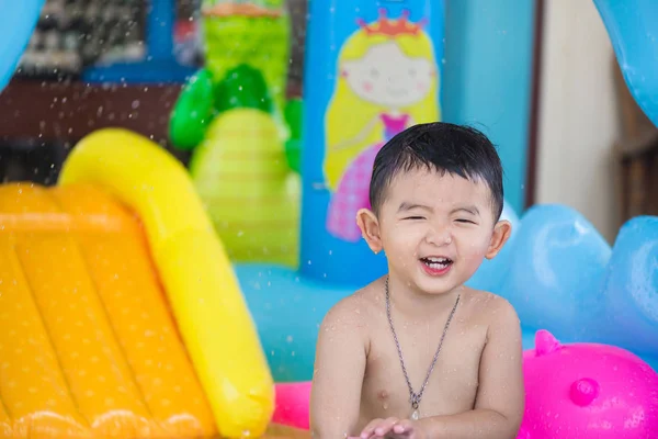 Asijský kluk hraje v nafukovací baby bazénu na horké léto — Stock fotografie