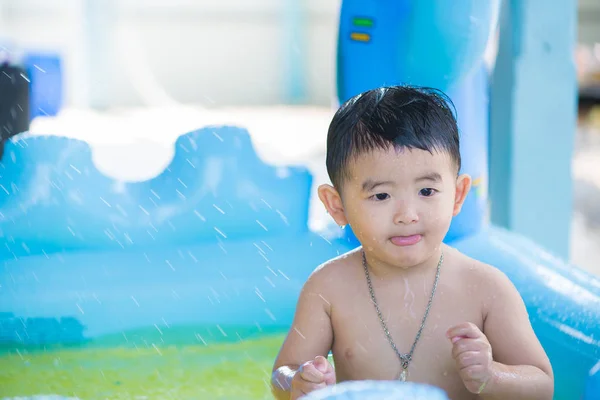 Niño asiático jugando en la piscina inflable del bebé en verano caliente — Foto de Stock