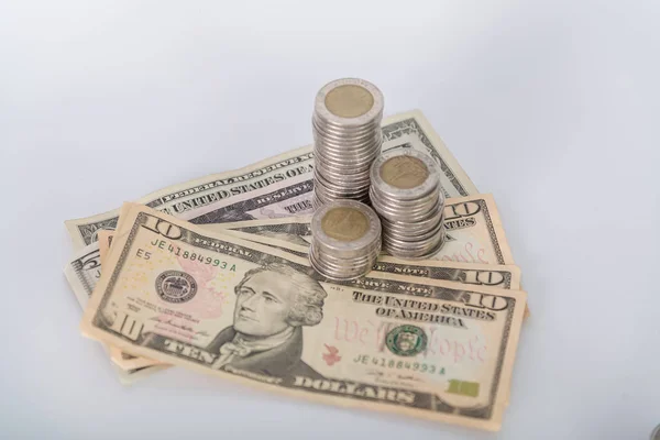 Piles of coins and dollar currency on white background — Stock Photo, Image