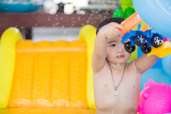 Niño asiático jugando en la piscina inflable del bebé en verano caliente —  Fotos de Stock