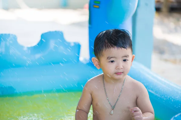 Niño asiático jugando en la piscina inflable del bebé en verano caliente — Foto de Stock