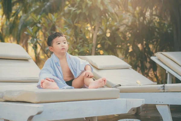Asiatique garçon avec serviette blanche reposant sur une chaise longue ou soleil — Photo