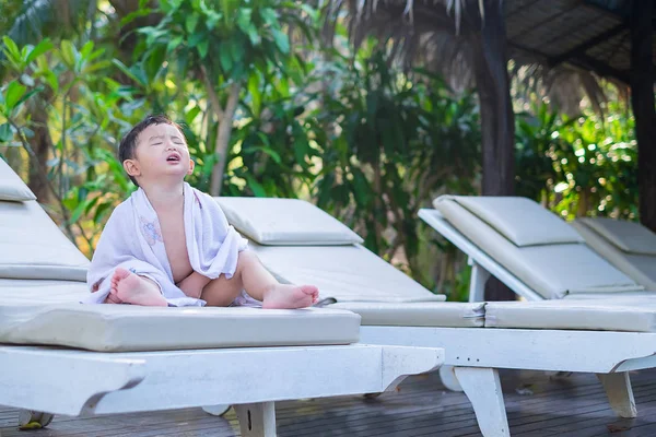Asiatique garçon avec serviette blanche reposant sur une chaise longue ou soleil — Photo