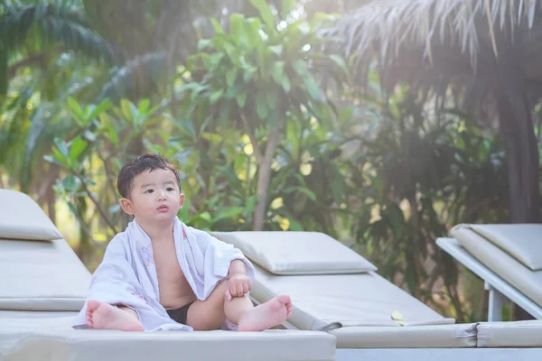 Asiatique garçon avec serviette blanche reposant sur une chaise longue ou soleil — Photo