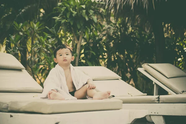 Asiatique garçon avec serviette blanche reposant sur une chaise longue ou soleil — Photo