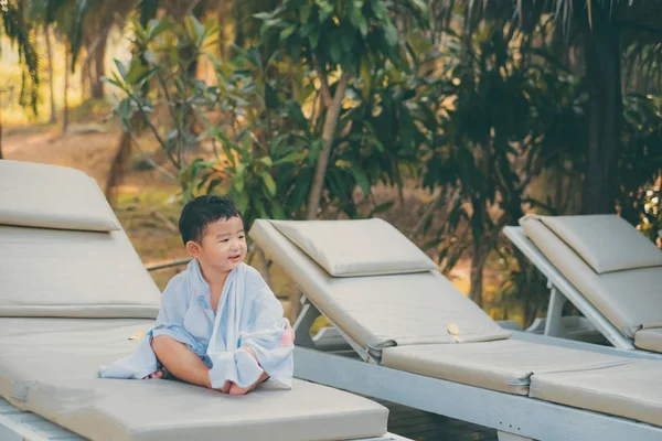 Asiatique garçon avec serviette blanche reposant sur une chaise longue ou soleil — Photo