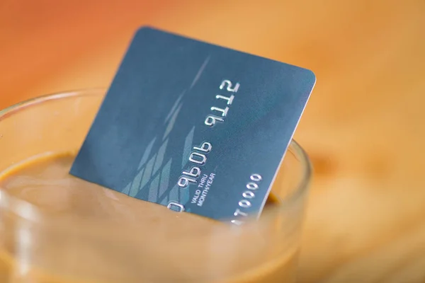 Кредитная карта и стакан горячего кофе на деревянном столе, мягкий тон . — стоковое фото