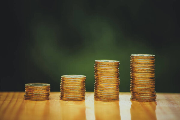 Growing coins stacks with green tree bokeh background. Financial