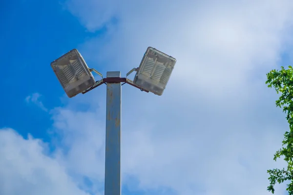 Lamp post electricity industry with blue sky background and tree