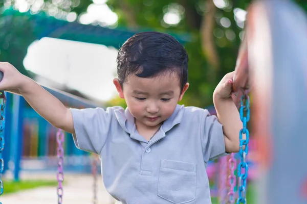 Asiático chico colgar el metal bar en al aire libre parque infantil . — Foto de Stock