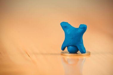 Mavi hamuru sikkeleri üzerinde w ile yapılmış minyatür insan figürü