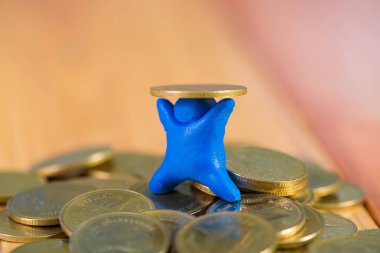 Mavi hamuru sikkeleri üzerinde w ile yapılmış minyatür insan figürü