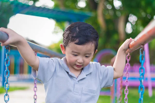 Asiático chico colgar el metal bar en al aire libre parque infantil . — Foto de Stock