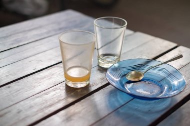 Boş bardak sıcak çay fincan tabağı ve ahşap masa kaşık,