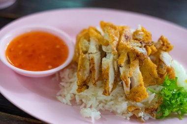 Kavrulmuş Tavuk pilav masada tabakta sebze ve sos ile,