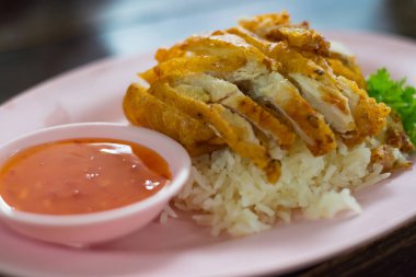 Kavrulmuş Tavuk pilav masada tabakta sebze ve sos ile,