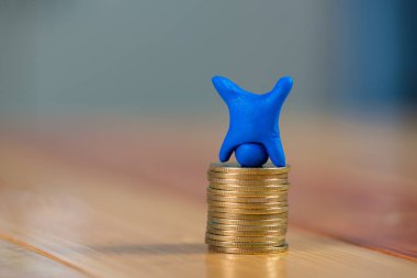 Mavi hamuru sikkeleri üzerinde w ile yapılmış minyatür insan figürü